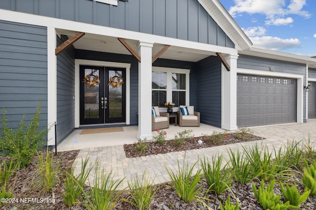 entrance to property with french doors, a porch, and a garage