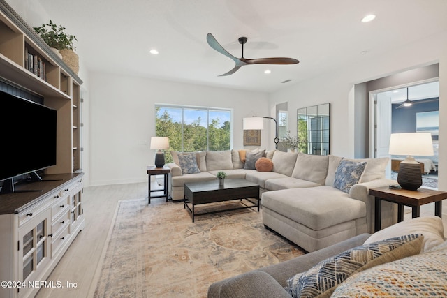 living room featuring ceiling fan and light wood-type flooring