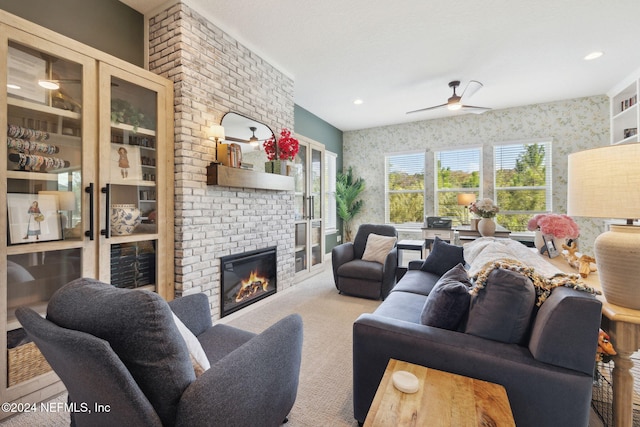 carpeted living room with ceiling fan and a fireplace