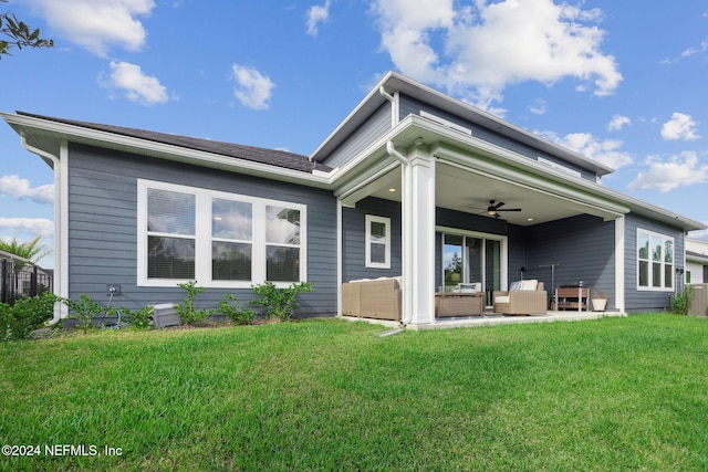 back of property with outdoor lounge area, ceiling fan, and a lawn