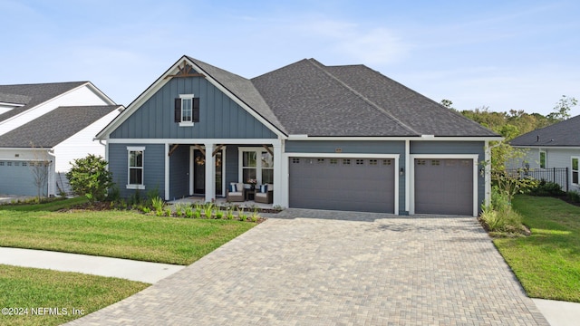 view of front of property with a porch, a garage, and a front yard