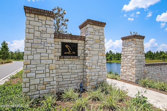 community sign featuring a water view