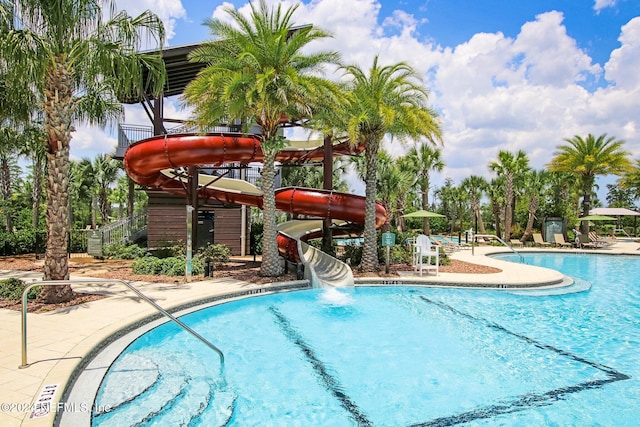 view of swimming pool with a patio area and a water slide