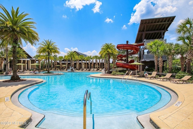 view of swimming pool with a patio and a water slide