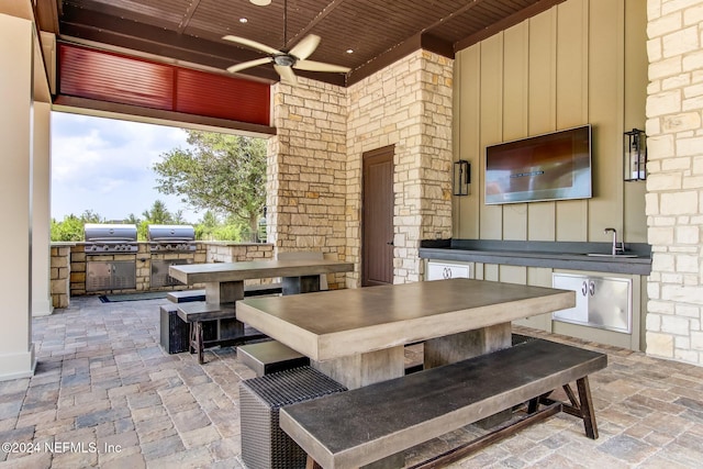 view of patio with ceiling fan, area for grilling, sink, and a grill