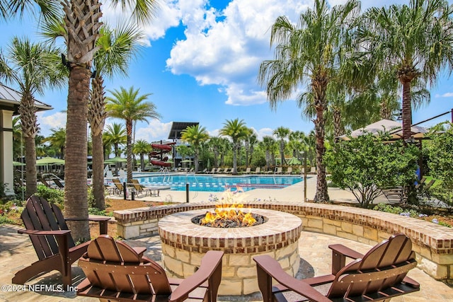 view of swimming pool with a patio and an outdoor fire pit