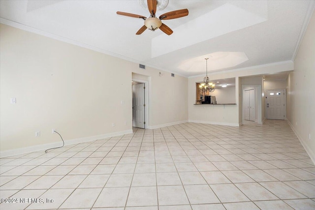 spare room featuring ceiling fan with notable chandelier, light tile patterned flooring, ornamental molding, and a tray ceiling