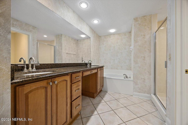 bathroom featuring tile patterned flooring, vanity, a textured ceiling, and plus walk in shower