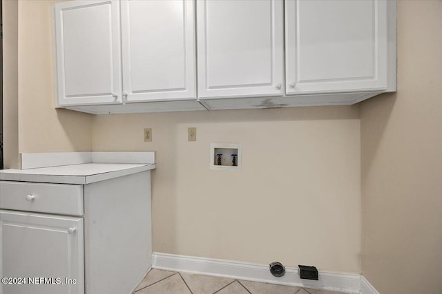 washroom featuring washer hookup, cabinets, and light tile patterned floors