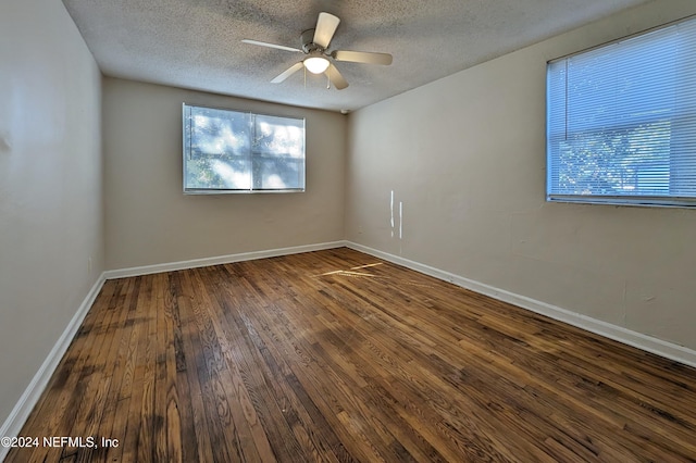 unfurnished room with a textured ceiling, ceiling fan, and dark wood-type flooring