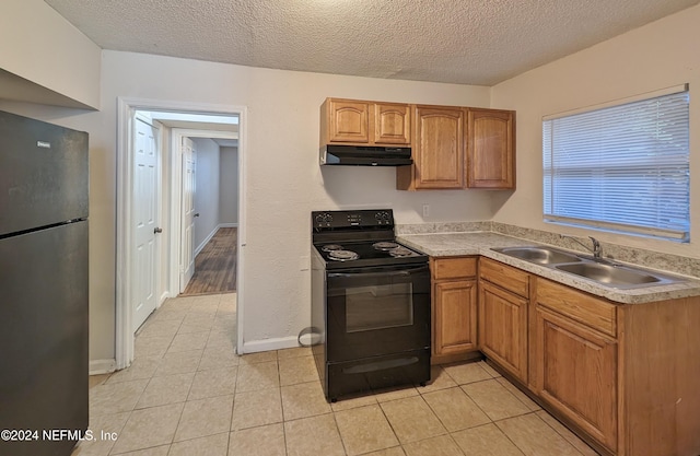 kitchen featuring stainless steel fridge, electric range, a textured ceiling, and sink