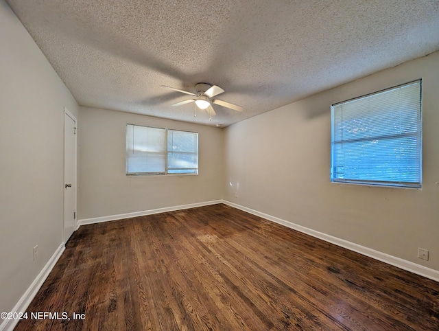 spare room featuring a textured ceiling, ceiling fan, and dark wood-type flooring