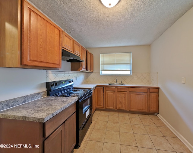 kitchen with black electric range oven, backsplash, sink, light tile patterned floors, and a textured ceiling