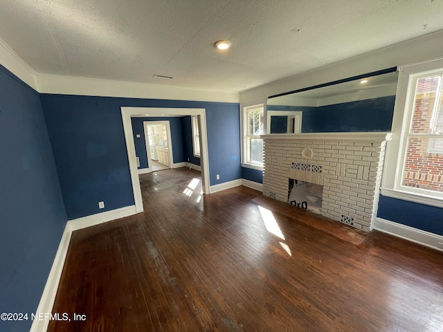 unfurnished living room featuring a textured ceiling, crown molding, a fireplace, and dark hardwood / wood-style floors