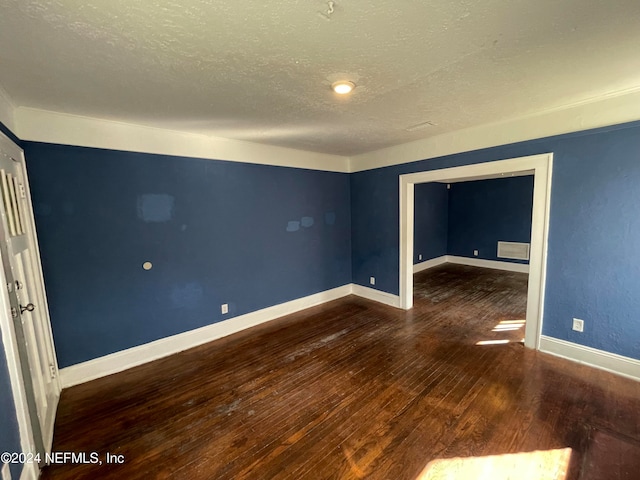 spare room with dark hardwood / wood-style flooring and a textured ceiling