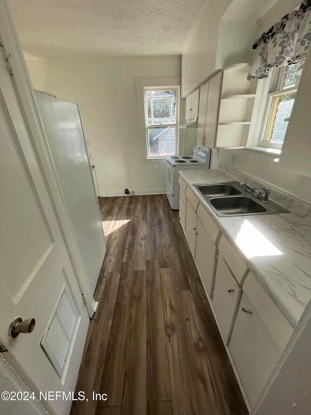 kitchen featuring white cabinetry, sink, dark wood-type flooring, white range with electric cooktop, and a textured ceiling