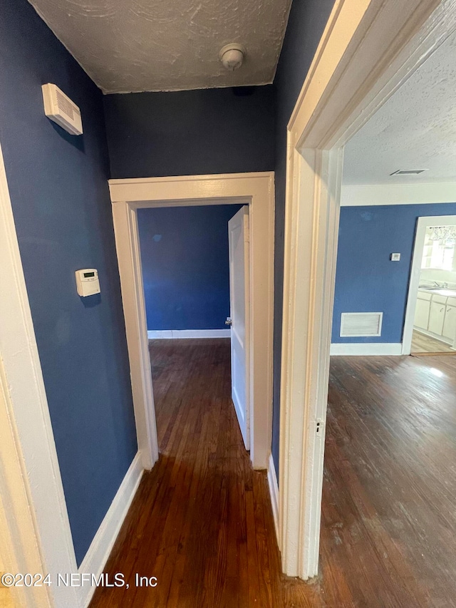 corridor featuring hardwood / wood-style floors and a textured ceiling