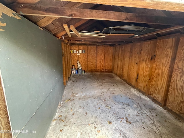 basement featuring wood walls