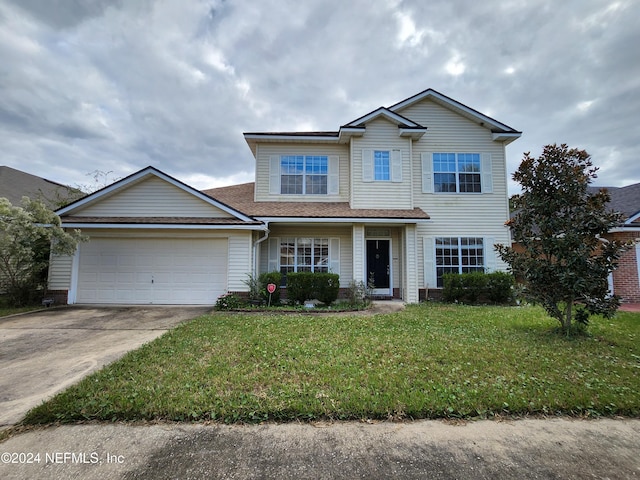 view of front of home with a front lawn and a garage