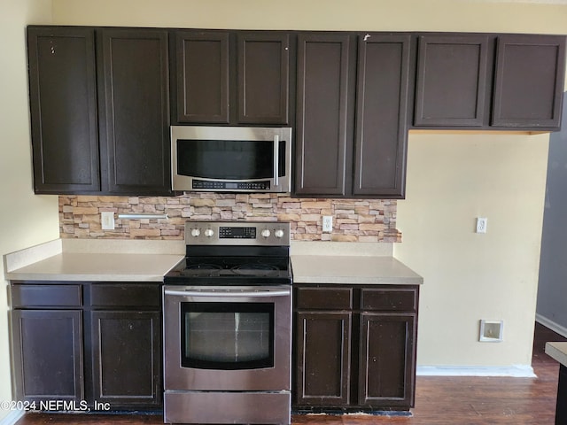 kitchen featuring appliances with stainless steel finishes, backsplash, and dark hardwood / wood-style floors