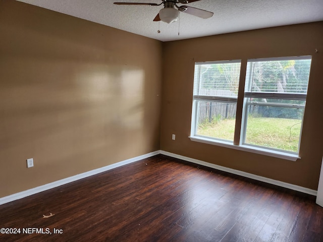 unfurnished room with a textured ceiling, ceiling fan, and dark wood-type flooring