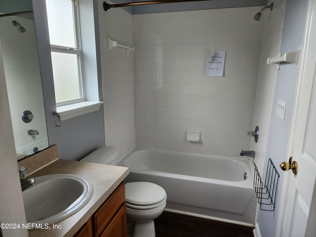 full bathroom featuring vanity, toilet, wood-type flooring, and tiled shower / bath