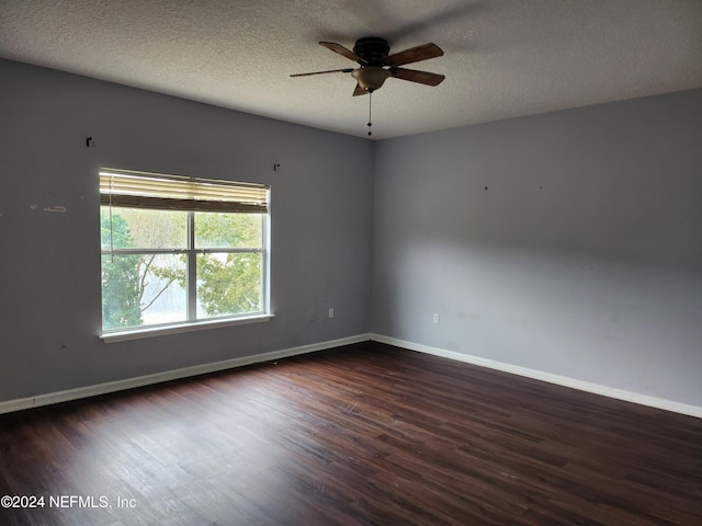 empty room with ceiling fan, a textured ceiling, and dark wood-type flooring