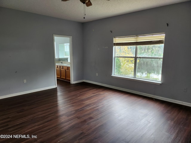 spare room with ceiling fan, dark hardwood / wood-style flooring, and a textured ceiling