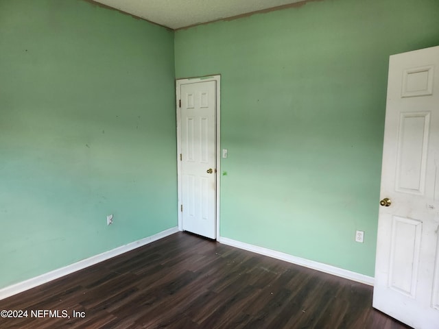 spare room with dark hardwood / wood-style flooring