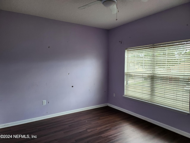 empty room featuring ceiling fan, dark hardwood / wood-style flooring, and a textured ceiling