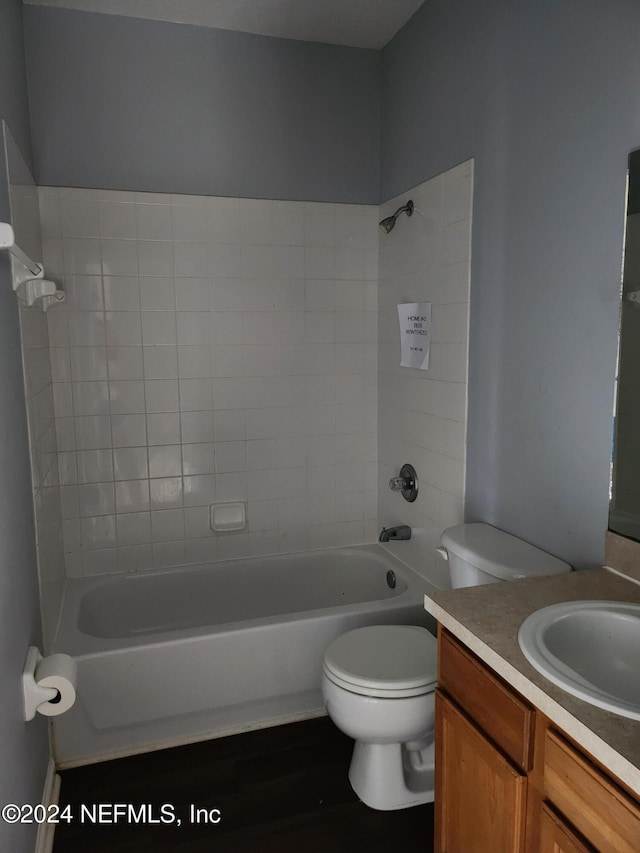 full bathroom featuring tiled shower / bath, hardwood / wood-style flooring, vanity, and toilet