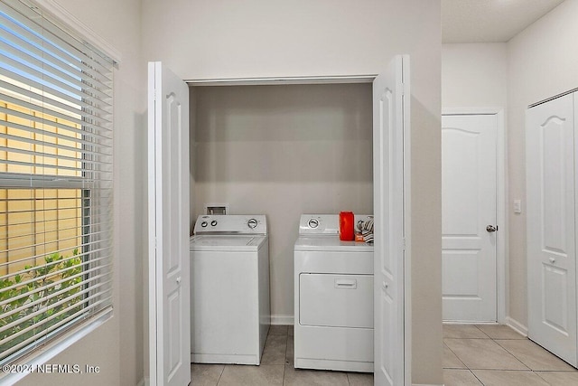 laundry area featuring separate washer and dryer and light tile patterned floors