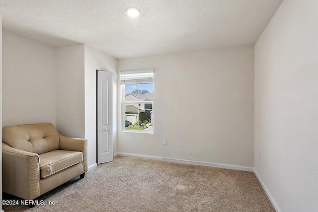 unfurnished room with light carpet and a textured ceiling