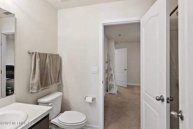 bathroom with vanity, toilet, and a textured ceiling