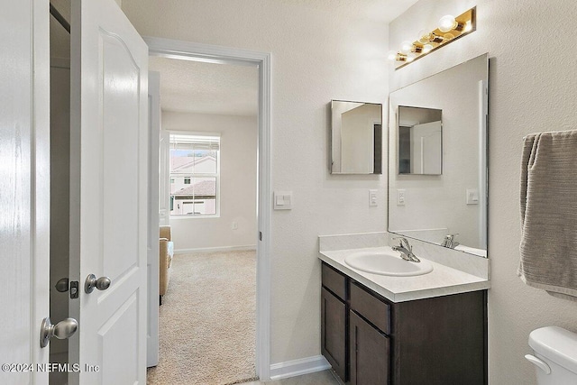 bathroom with vanity, a textured ceiling, and toilet