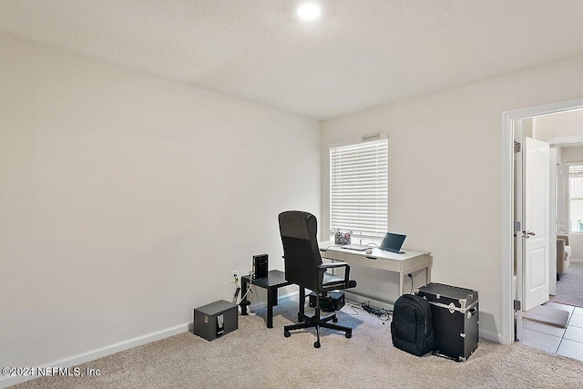 home office featuring a textured ceiling, light colored carpet, and plenty of natural light