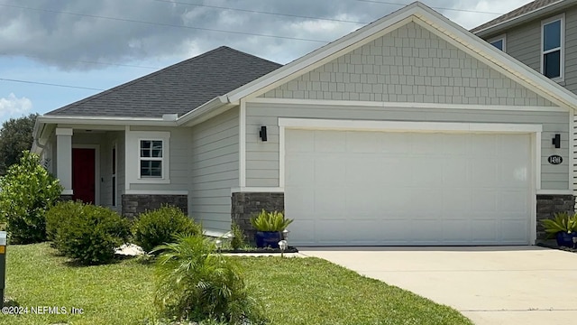 craftsman inspired home featuring a garage and a front lawn