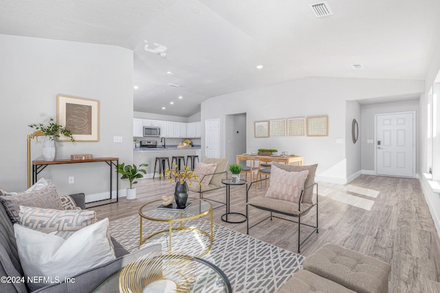 living room with light wood-type flooring and lofted ceiling