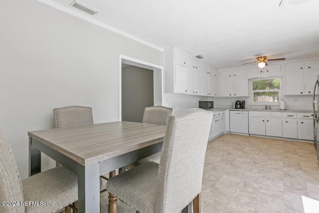 dining area featuring ceiling fan, crown molding, and sink