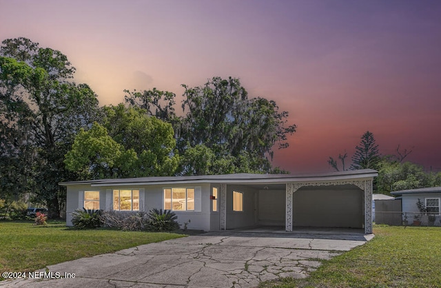 single story home featuring a lawn and a carport