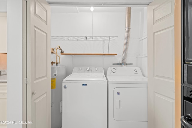 washroom with washing machine and dryer and water heater