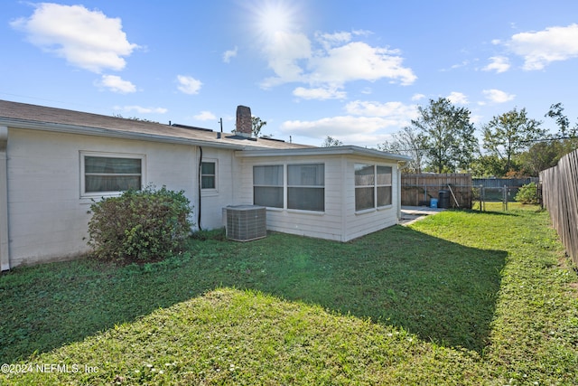 back of property with a lawn and central AC unit