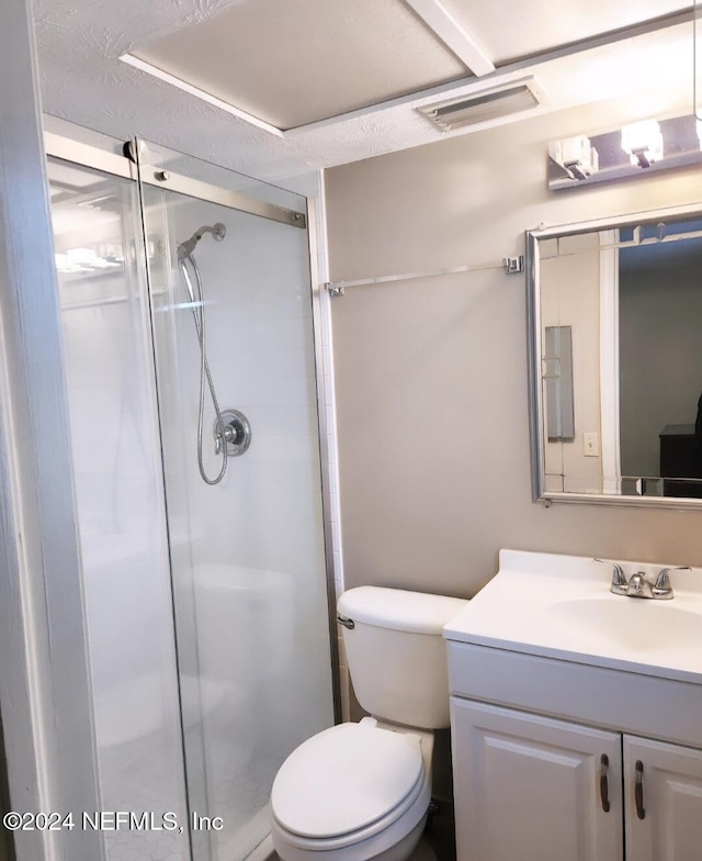 bathroom featuring a textured ceiling, vanity, toilet, and walk in shower