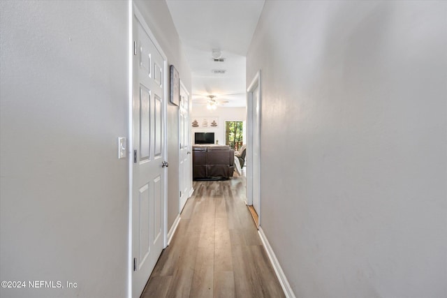 hallway with hardwood / wood-style floors