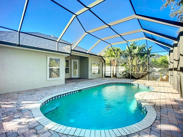 view of pool featuring glass enclosure and a patio area