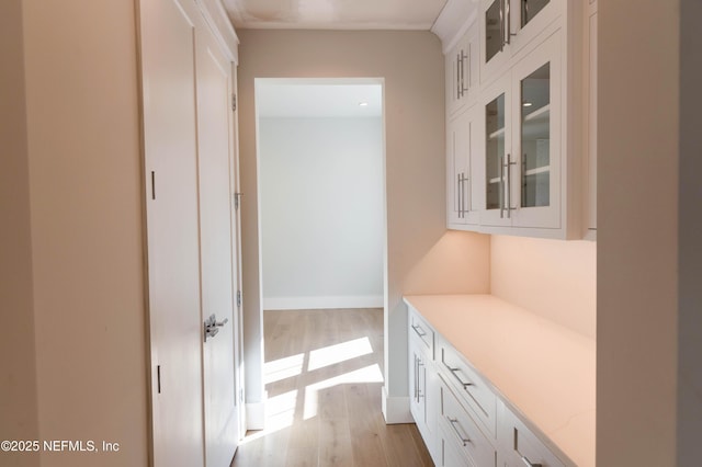 hallway featuring light wood-style flooring and baseboards