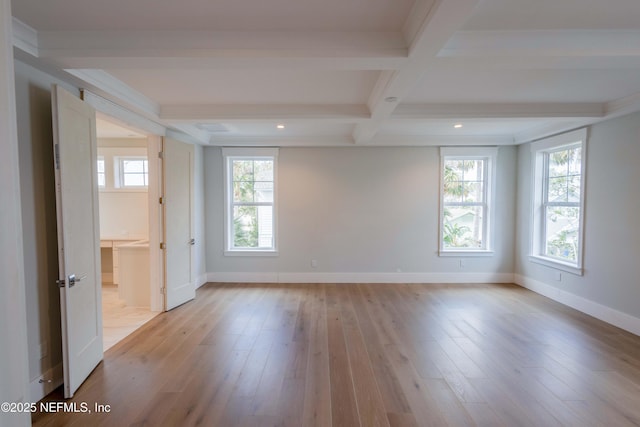 spare room featuring light wood finished floors, baseboards, coffered ceiling, and beamed ceiling