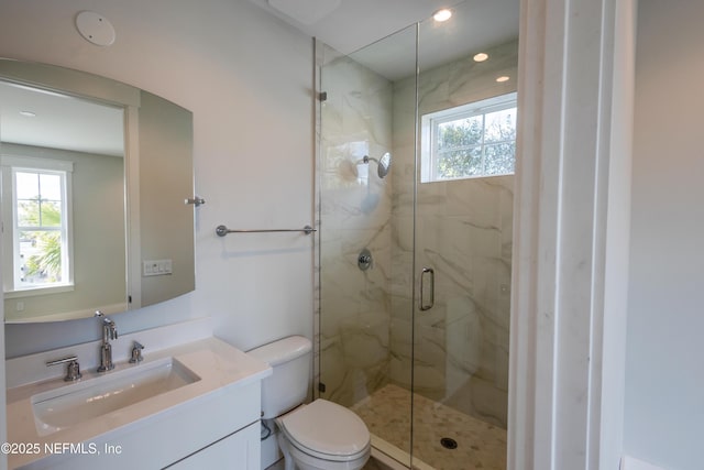 full bathroom with a wealth of natural light, toilet, vanity, and a marble finish shower