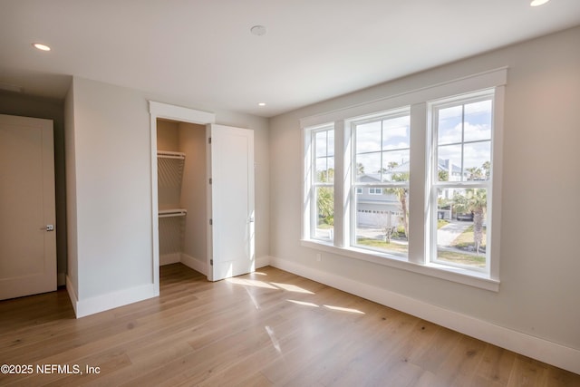 unfurnished bedroom featuring light wood-style flooring, baseboards, and recessed lighting