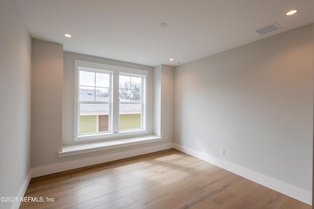 empty room with recessed lighting, visible vents, light wood-style flooring, and baseboards